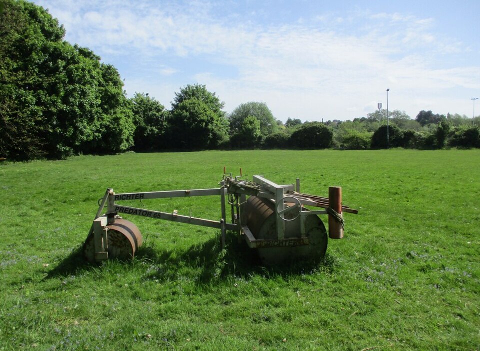 Large smooth roller sitting on a maintained grass field